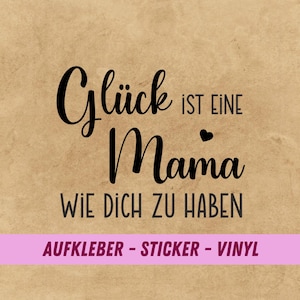 Könnte beinhalten: Brauner Hintergrund mit schwarzem Text: "Glück ist eine Mama wie dich zu haben" mit Herzsymbol. Darunter ein pinkfarbenes Banner mit "AUFKLEBER - STICKER - VINYL".