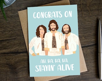 May include: A blue card with a white border and the text "CONGRATS ON" in white. Three cartoon figures are shown in white jackets with brown chest hair. The text "AH. HA. HA. HA. STAYIN' ALIVE" is in white at the bottom of the card.