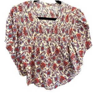 Peut inclure: Un chemisier &agrave; manches courtes &agrave; imprim&eacute; floral blanc, rouge et bleu avec une taille &eacute;lastique fronc&eacute;e.