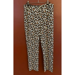 May include: A pair of brown and white leopard print pants. The pants have a straight leg and a mid-rise waist.