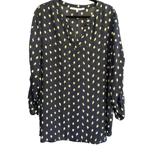 May include: A navy blue long-sleeved blouse with a white polka dot pattern. The blouse has a v-neck and a relaxed fit.