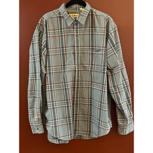 May include: A long-sleeved plaid shirt with a button-down collar and a pocket on the left chest. The shirt is in a blue, white, and red plaid pattern. The shirt has the L.L. Bean logo on the collar.