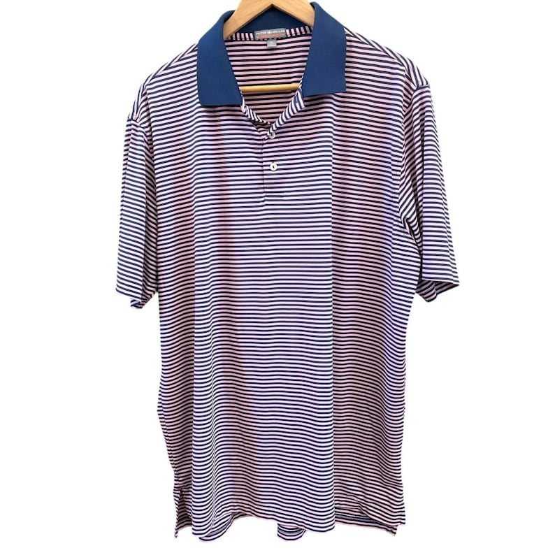 May include: A short-sleeved polo shirt with horizontal stripes in navy blue and light red. The shirt has a navy blue collar and a three-button placket. The shirt is hanging on a wooden hanger.