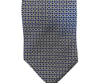 May include: A navy blue tie with a repeating geometric pattern of interlocking circles and squares in white and dark blue. The tie is made of a smooth fabric and is suitable for formal or business attire.