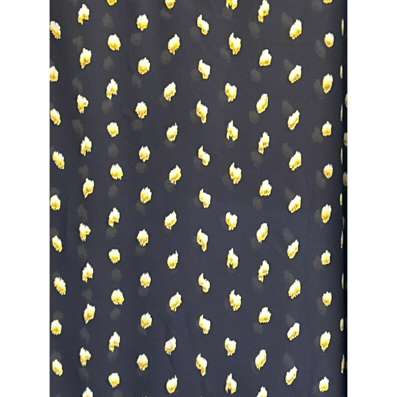 May include: A dark blue fabric with a repeating pattern of small, yellow, irregular shapes.