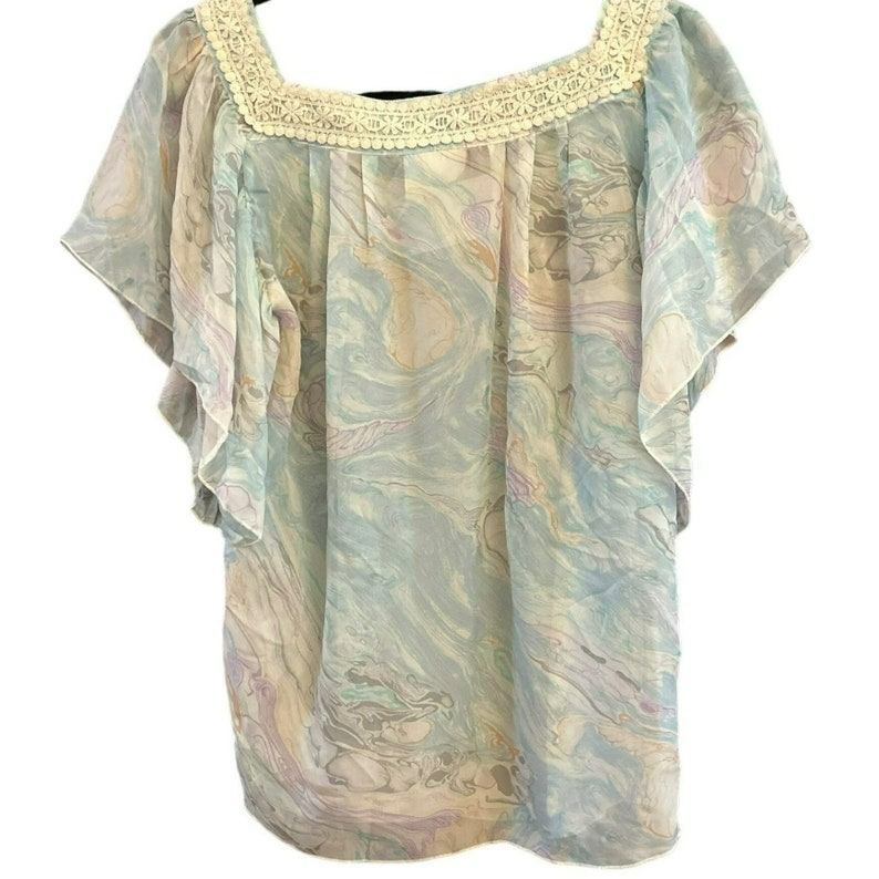 May include: A light blue, sheer blouse with a marbled pattern. The blouse has a square neckline and short, ruffled sleeves. The neckline is trimmed with white crochet.