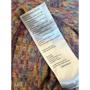 May include: A close-up of a clothing tag with a colorful, abstract pattern. The tag lists the fabric composition, care instructions, and the brand name "Urban Outfitters".
