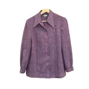 May include: A purple herringbone-patterned button-down shirt with a pointed collar and long sleeves. The shirt has red buttons and is hanging on a wooden hanger. The Givenchy label is visible at the collar.