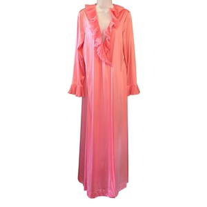 May include: A floor-length coral pink robe featuring long sleeves with ruffled cuffs and a deep V-neckline adorned with cascading ruffles that extend down the front opening. The garment is made of a smooth, lightweight fabric with a subtle sheen.
