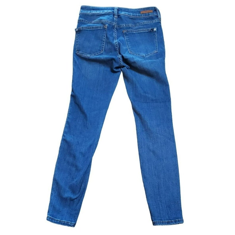 May include: A pair of blue denim jeans with a slim fit. The jeans have a classic five-pocket style and a mid-rise waist.
