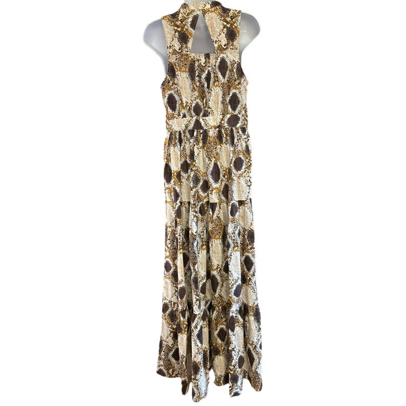May include: A sleeveless maxi dress with a snakeskin print in shades of brown, beige, and gold. The dress has a high neckline and a tiered skirt.