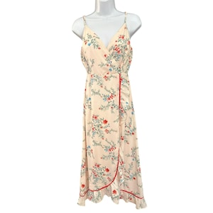 May include: A light pink maxi dress with a floral print and a red trim. The dress has a V-neckline and spaghetti straps.