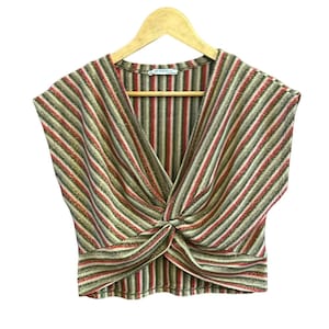 K&ouml;nnte beinhalten: Ein &auml;rmelloses, gestreiftes Oberteil mit einem Twist-Detail an der Vorderseite. Das Oberteil ist aus einem glitzernden Stoff gefertigt und hat einen V-Ausschnitt. Die Streifen sind in Gold-, Rot- und Braunt&ouml;nen gehalten.