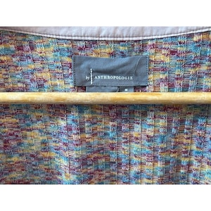 May include: A multi-colored striped cardigan with a gray tag that reads "by Anthropologie" and a size "M".