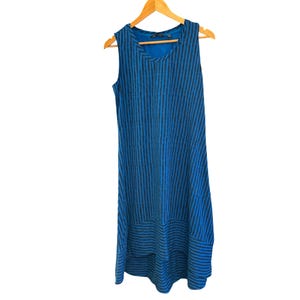 May include: A blue and black striped sleeveless dress with a high-low hemline. The dress is hanging on a wooden hanger.
