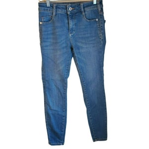 May include: A pair of blue denim jeans with a slim fit. The jeans have a classic five-pocket style and a zipper fly.
