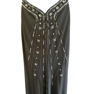 Puede incluir: Un vestido negro sin mangas con lentejuelas plateadas e iridiscentes en un patr&oacute;n geom&eacute;trico.