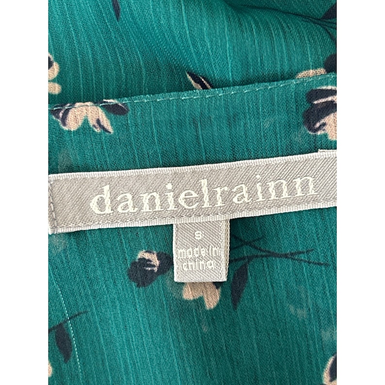 May include: A green floral print dress with a white tag that says "danielrainn" and "made in china" in black text.