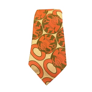 May include: A necktie featuring a repeating pattern of orange and dark olive green circular motifs. Each circle contains a stylized figure with geometric lines and shapes. The background is a light cream color with a subtle, fine-lined texture.