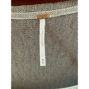 May include: A white mesh top with a Free People tag. The tag says "Made in China" and "Fabriqu&eacute; en Chine". The size tag says "M".