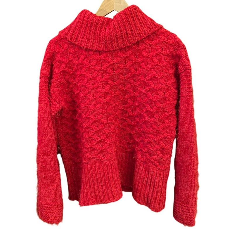 May include: A vibrant red sweater with a textured knit pattern and a wide, ribbed turtleneck. The sweater has long sleeves and a ribbed hem, displayed on a wooden hanger against a white background. The knitwear appears soft and warm.