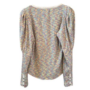 May include: A long-sleeved, multi-colored, knit top with a scoop neck and button detailing on the cuffs.