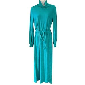 Peut inclure: Une robe longue à manches longues d'un bleu sarcelle éclatant. Le vêtement présente un col roulé haut, un tissu texturé en maille gaufrée et une taille à cordon de serrage avec des liens assortis permettant un ajustement réglable au niveau de la taille.