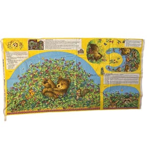Peut inclure: Un panneau de tissu avec une illustration fantaisiste d'un ourson dans un buisson de baies. Le motif comprend d'autres animaux de la forêt, des baies et du texte sur un fond jaune et bleu. Le tissu est rectangulaire.