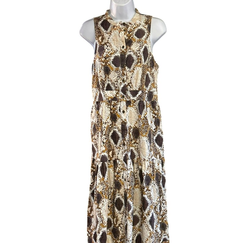 May include: A sleeveless maxi dress with a snakeskin print in shades of brown, white, and gold. The dress has a button-up front and a tiered skirt.