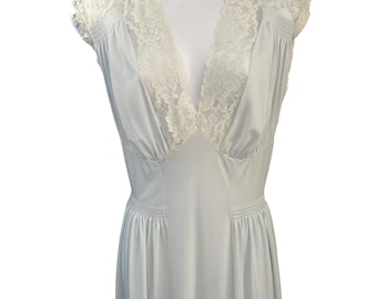 May include: A light blue sleeveless nightgown featuring a deep V-neckline trimmed with white floral lace. The garment has gathered fabric at the shoulders and waist, creating a soft, flowing silhouette with a smooth, solid-colored skirt section.
