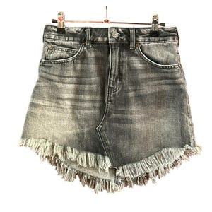 May include: A grey denim skirt with a frayed hem. The skirt has a high waist and a straight fit.