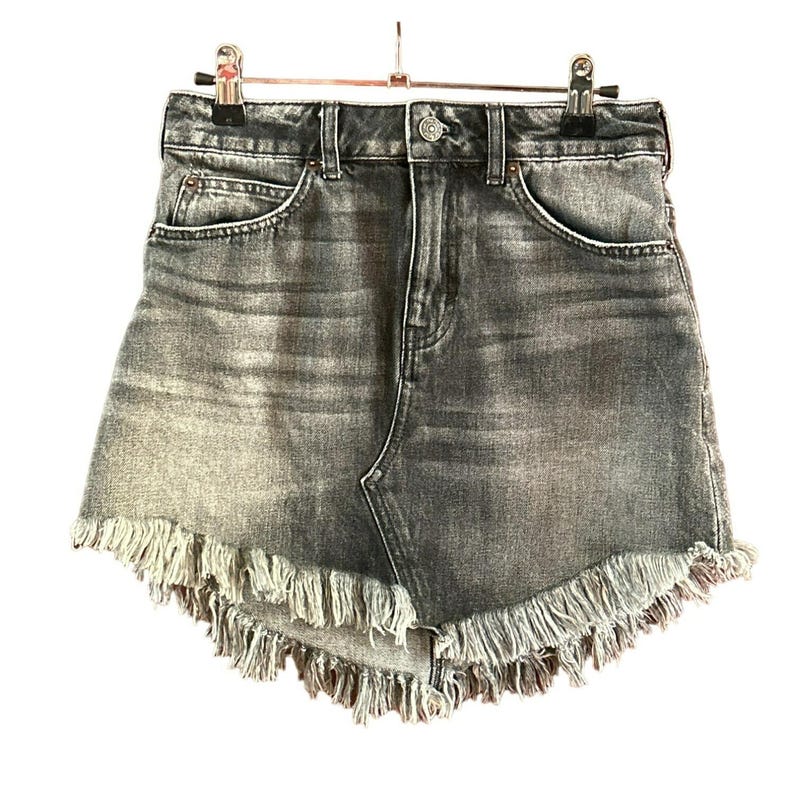 May include: A grey denim skirt with a frayed hem. The skirt has a high waist and a straight fit.