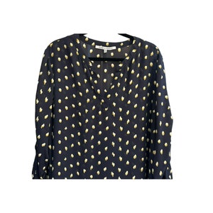 May include: A navy blue long-sleeved blouse with a white polka dot pattern. The blouse has a v-neck and a button closure at the neckline. The brand name "Collective Concepts" is visible on the tag.