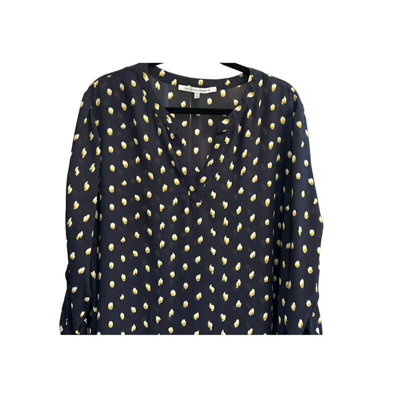 May include: A navy blue long-sleeved blouse with a white polka dot pattern. The blouse has a v-neck and a button closure at the neckline. The brand name "Collective Concepts" is visible on the tag.