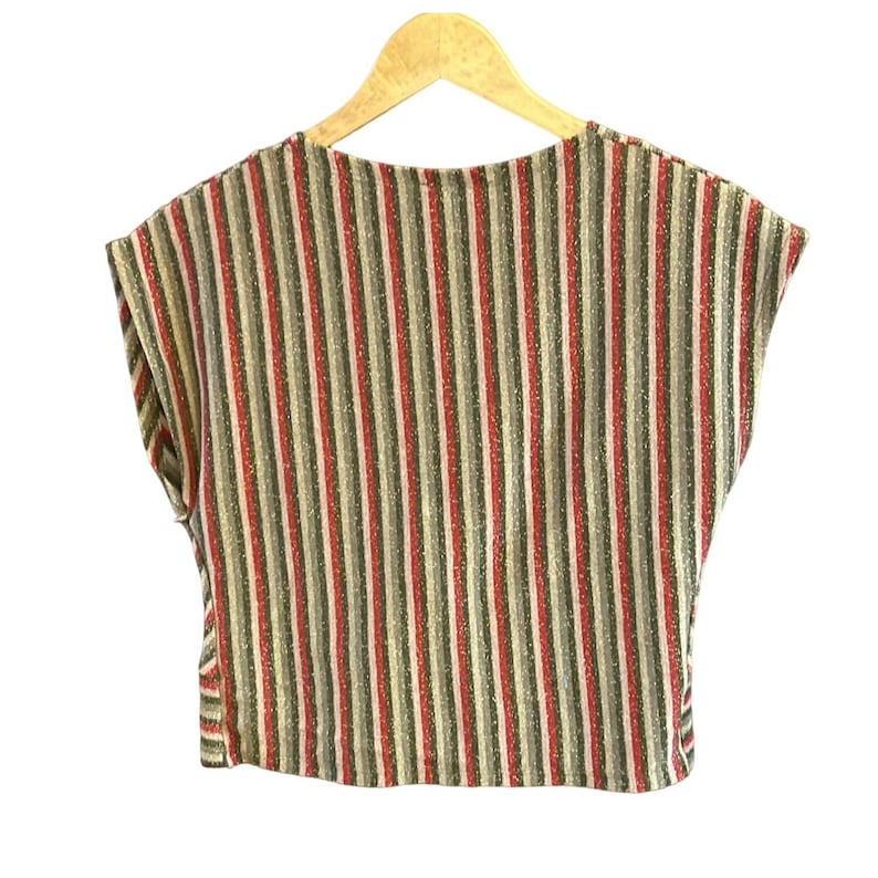 K&ouml;nnte beinhalten: Ein gestreiftes, bauchfreies Oberteil mit Rundhalsausschnitt und kurzen &Auml;rmeln. Das Oberteil ist aus einem weichen, glitzernden Stoff in Rot-, Gr&uuml;n- und Beiget&ouml;nen.