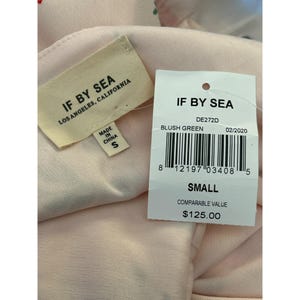 May include: A white tag with black text that reads "IF BY SEA" and "DE272D" with the words "BLUSH GREEN" and "02/2020" below. A barcode is below the text. The tag also says "SMALL" and "COMPARABLE VALUE $125.00".