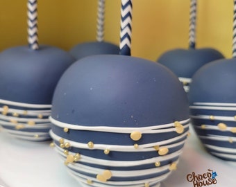 May include: Navy blue candy apples with white and gold accents. Each apple is decorated with white stripes and gold sprinkles. The apples are on sticks with blue and white chevron patterns. The logo for Choco House is visible in the bottom right corner.