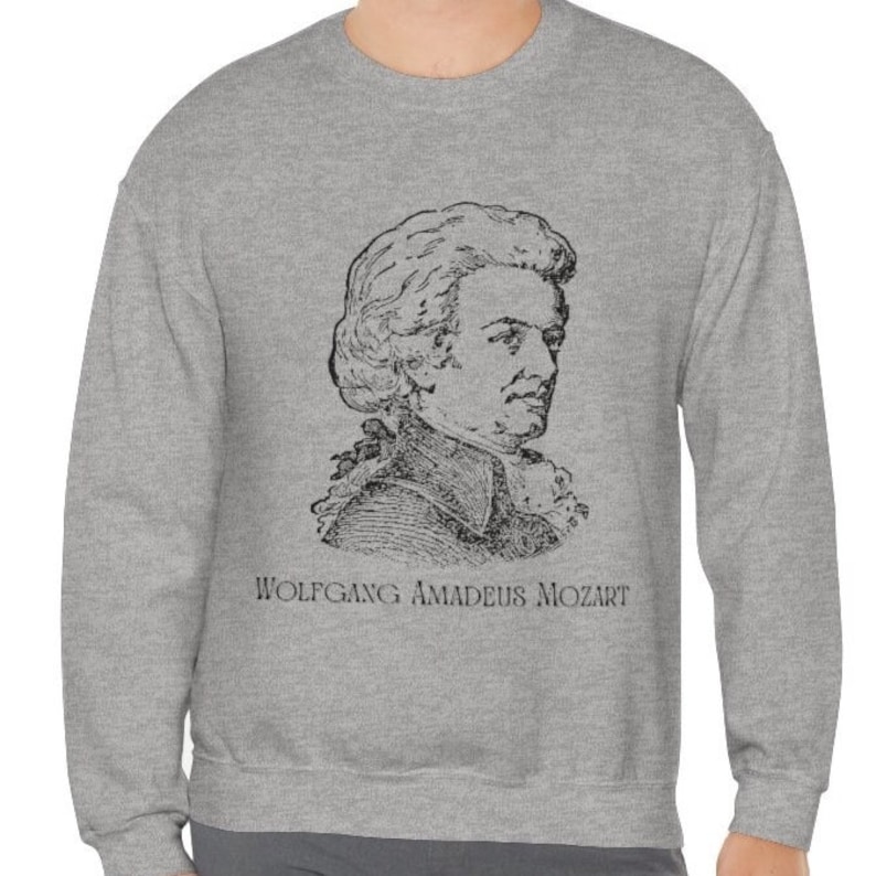 May include: A gray sweatshirt with a black and white illustration of Wolfgang Amadeus Mozart on the front. The text "Wolfgang Amadeus Mozart" is printed below the illustration.