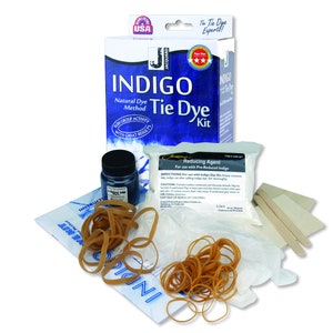 May include: Indigo Tie Dye Kit with a blue and white box, a bottle of indigo dye, a bag of reducing agent, rubber bands, gloves, and wooden sticks. The box says "Fun Group Activity with Great Results".