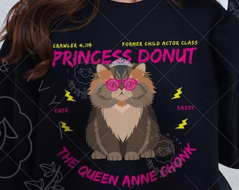 May include: Black sweatshirt featuring a cartoon cat wearing pink glasses and a crown, with the text "PRINCESS DONUT" and "THE QUEEN ANNE CHONK". The sweatshirt has the text "CRAWLER 4.19" and "FORMER CHILD ACTOR CLASS".