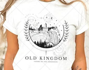 May include: White t-shirt with a black and white graphic design of a waterfall, a castle, and trees in a circle with the text "OLD KINGDOM - HOME OF THE ABHORSEN -" below.