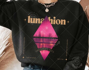 May include: Black sweatshirt with a graphic design of a city skyline reflected in a diamond shape. The text "lunahion" is above the graphic and "CRESCENT CITY" is below the graphic.