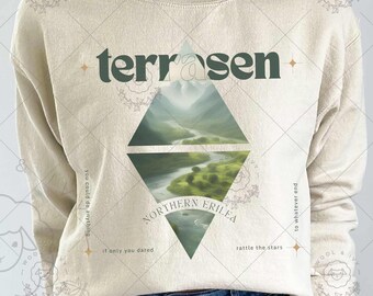 May include: A beige sweatshirt with a green and white graphic design featuring a mountain landscape and the text "terrosen" and "NORTHERN ERILEA". The text "rattle the stars" and "to whatever and" are also included in the design.