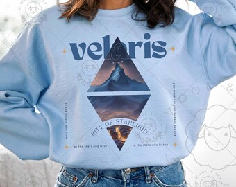 May include: Light blue sweatshirt with a graphic design of a mountain range and the text "velaris" and "CITY OF STARLIGHT" with the text "to the people who look at the stars and wish to the stars who listen and the dreams that are answered".
