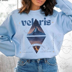 Puede incluir: Sudadera azul claro con un dise&ntilde;o gr&aacute;fico de una cordillera y el texto "velaris" y "CITY OF STARLIGHT" con el texto "to the people who look at the stars and wish to the stars who listen and the dreams that are answered".