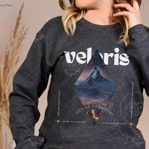 Puede incluir: Una sudadera gris oscuro con un estampado gr&aacute;fico blanco de la palabra "veloris" y una escena de monta&ntilde;a. El texto debajo del gr&aacute;fico dice: "a la gente que mira las estrellas y desea a las estrellas que escuchan y a los sue&ntilde;os que son respondidos".