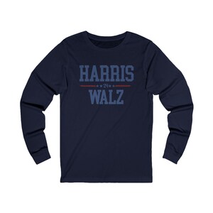 May include: Navy blue long-sleeve shirt with the text "HARRIS WALZ" in blue with red stars above the text.
