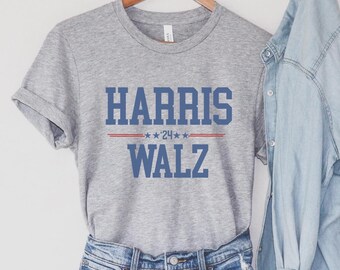 May include: Gray t-shirt with the text "HARRIS ***'24*** WALZ" in blue and red.