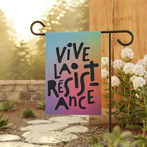 May include: A garden flag with a rainbow gradient background and black text that reads "VIVE LA RESISTANCE".