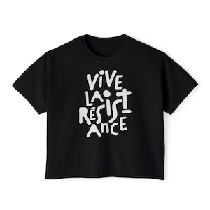 May include: Black t-shirt with the white text "VIVE LA R&Eacute;SISTANCE" in a bold, handwritten style. The shirt has a classic crew neck and short sleeves, suitable for casual wear.